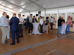 Guests in the tent in fron of roll-ups portraying the company history
